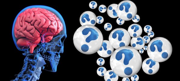 On the right side of the image is an Illustration of a human head (skull) on a black background with a deep pink brain contained therein.  On the left side are many blue question marks in floating bubbles of varying size. They represent the confusion and barrage of thoughts that many with Brain Injuries often experience. 