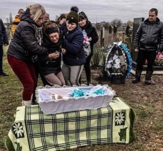 This is a devastating photo of the family grieving at the...