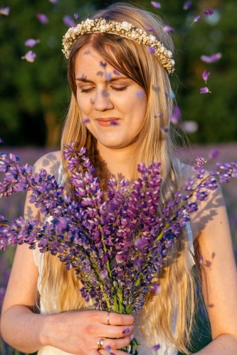 The photo of a woman holding a bouquet of lupines.